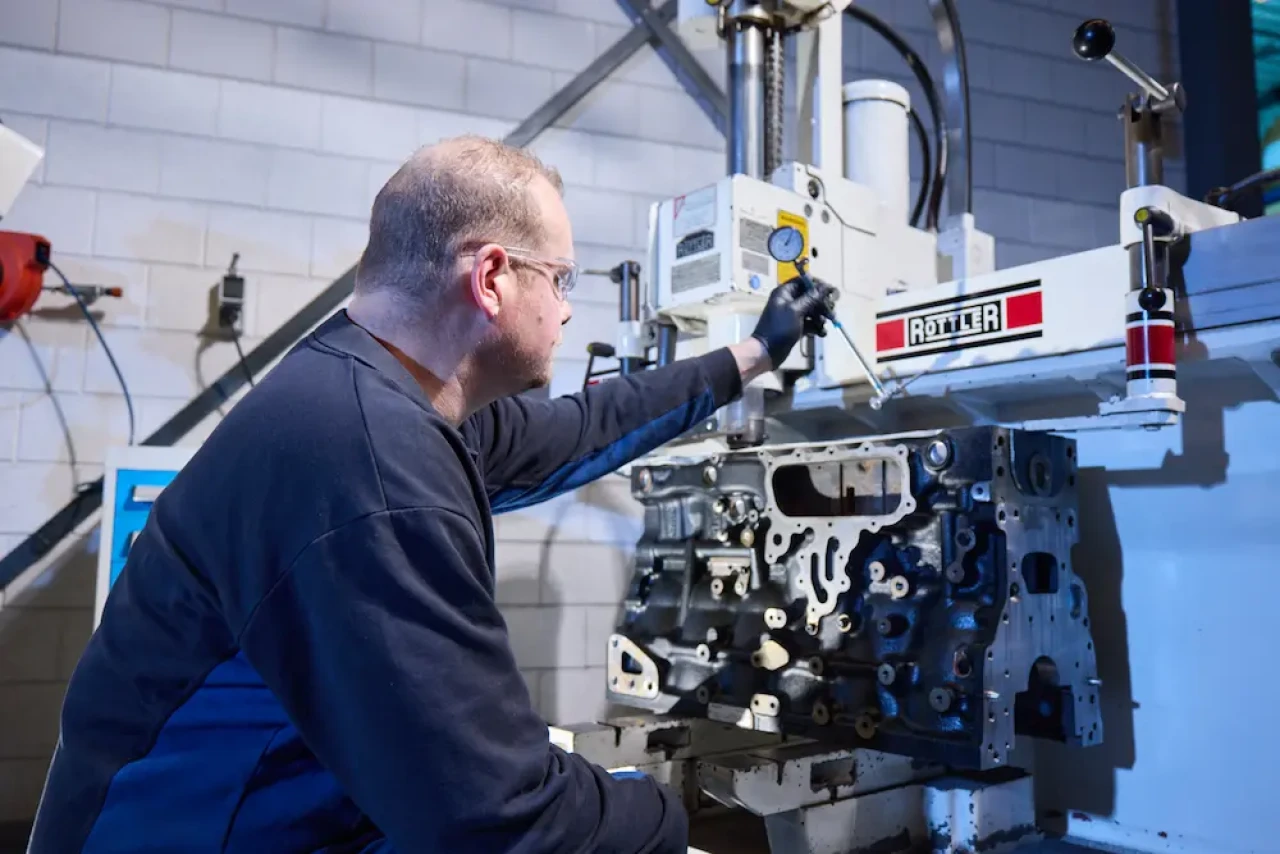 Servicetechniker bei der Motorrevision eines Notstromaggregats während des Honens zur Instandsetzung der Zylinderlaufflächen